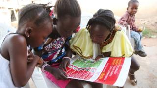 Girls looking at a poster about Ebola