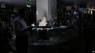 A Bangladeshi customer walks past a salesgirl in Dhaka, Bangladesh on 1 Nov 2014