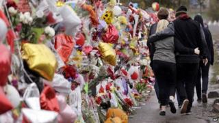 People walk past a memorial outside Marysville-Pilchuck High School following a deadly shooting there on 24 October (30 October 2014)
