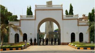 Sudanese security guards stand at the gate of the presidential palace in Khartoum in 2010