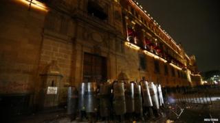 Policemen block the wooden door of Mexican President Enrique Pena Nieto"s ceremonial palace during a protest 8 Oct 2014
