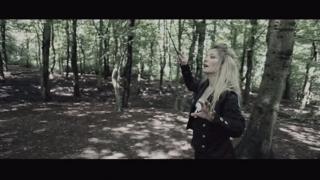 Woman waving wand in a forest