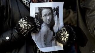 Woman holds a picture of Rehtaeh Parsons in Halifax, Nova Scotia on 11 April 2013