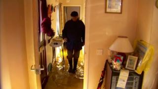 Brendan McCann walks through his flooded home in Portadown