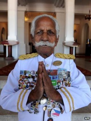 In this photograph taken on February 6, 2010, Sri Lanka's legendary doorman, Kottarapattu Chattu Kuttan holds his palms in a traditional greeting, outside the island's historic 146-year-old Galle Face Hotel in Colombo.