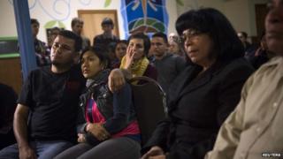 Undocumented immigrant Angela Navarro and her husband Ermer Fernandez (L), along with other immigrants and supporters, watch U.S. President Barack Obama speak 20 November 2014