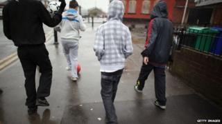 Teenagers playing football in street