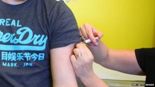 A young man receives an MMR jab