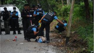 Thai police inspect the scene of a bomb blast in Narathiwat province (15 Nov 2014)