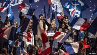 Leader of France's National Front party Marine Le Pen waves at the audience on 30 November 2014 in Lyon