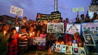 Survivors and relatives of Bhopal gas victims hold photos of the victims during a candle light vigil on the eve of the 30th anniversary of the tragedy on 1 December 2014.