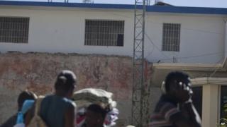 Residents walk by the Saint-Marc prison on 1 December, 2014.