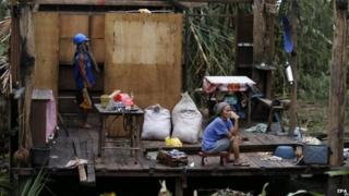 Woman sits in ruined house in Taft, Samar, Philippines (7 Dec 2014)