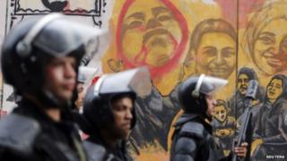 Riot police in front of a mural in Cairo's Tahrir Square remembering those killed in the 2011 uprising against Hosni Mubarak (19 November 2014)
