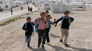 Syrian refugees play at the Al Zaatari refugee camp in the Jordanian city of Mafraq (7 December 2014)