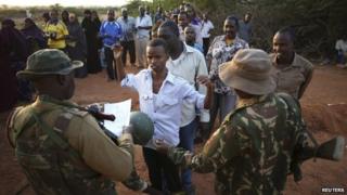 Passengers travelling to Nairobi wait to be searched for weapons in the town of Mandera at the Kenya-Somalia border, 8 December 2014
