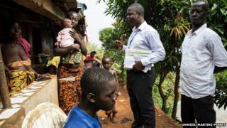 A disease surveillance officer working for Operation Western Area Surge visits a family in Moyinba, Sierra Leone
