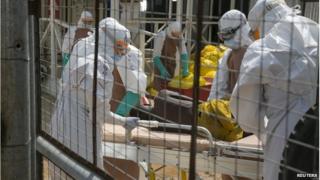 British health workers with an Ebola patient near Freetown, Sierra Leone, 22 December 2014