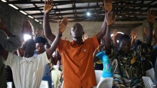 Church members pray during a Sunday service on 24 August 2014 in Dolo Town, Liberia