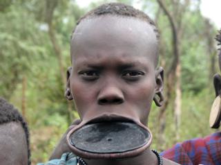A young Mursi woman with a traditional plate in her lip