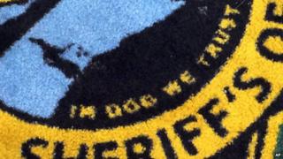 A rug in a US sheriff's office mistakenly reading 'in dog we trust'