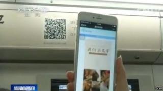 A person holding a phone to scan the barcode on the metro carriage