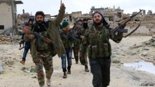 Opposition fighters walk in the Syrian town of Aleppo after they reportedly re-took control of the area from pro-government forces on 7 January 2015