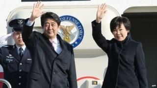 Japanese Prime Minister Shinzo Abe (left) and his wife Akie wave to well-wishers upon their departure at Tokyo's Haneda airport, 16 January 2015