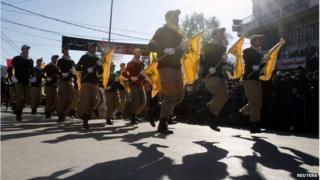 Lebanese Hezbollah supporters carry flags while marching during a religious procession in Nabatieh on 7 November 2014.