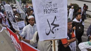 Indonesian Muslim men display posters during a protest against the caricature of Prophet Muhammad published in French satirical weekly Charlie Hebdo, outside the local office of French Alliance in Medan, North Sumatra, Indonesia, 23 January 2015.