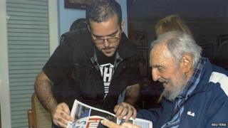 Former Cuban President Fidel Castro and Randy Perdomo look at a newspaper during a meeting in Havana in this picture provided by Cubadebate on 2 February 2015