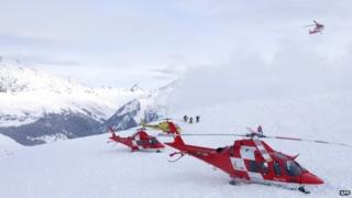 Helicopters land at the site of an avalanche that hit nine skiers on 31 January