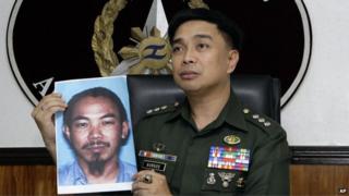 In a 2 Feb 2012 photo, then armed forced spokesman Col Marcelo Burgos shows a picture of Malaysian Zulkifli bin Hir