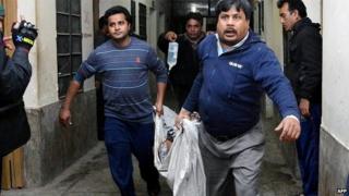 Rescuers carry a man with burn injuries after the petrol bomb attack on a bus from Gaibandha to Dhaka, 7 February 2015