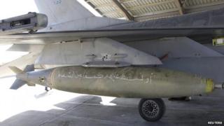 A bomb with Koranic verses is pictured on a Royal Jordanian Air Force plane at an air base before a raid on IS