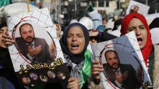 Protesters from the Islamic Action Front, carry pictures of the deputy overall leader of Jordanian Muslim Brotherhood Zaki Bani Rsheid during a demostration to show their solidarity with Palestinians and anger at the political arrest, after the Friday prayer in Amman November 28, 2014
