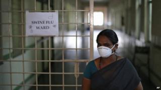 An Indian security woman covers her face with a mask outside the swine flu ward of Gandhi Hospital in Hyderabad, Feb 20