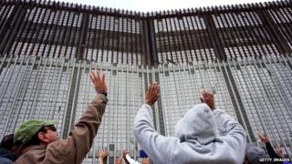 Worshipers participate in a Mass along the US-Mexico border wall on Tijuana, Mexico 22 February 2015