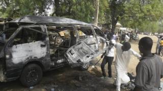 Men inspect a bus following an explosion on the street in Potiskum, Nigeria, on Tuesday 24 February 2015