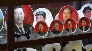 Decorative plates featuring Chinese leaders (L-R) current President Xi Jinping, Mao Zedong, Deng Xiaoping, Jiang Zemin and Hu Jintao are seen above a row of Pandas in a shop window in Beijing