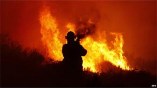 A firefighter tries to stop a blaze in Noordhoek Manor old age home, Cape Town, South Africa, 02 March 2015