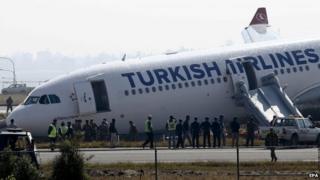 Nepalese emergency officials inspect a Turkish Airlines airbus after it skidded off from the runway at Tribhuvan International Airport in Kathmandu, Nepal on 4 March 2015