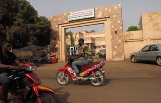 Motorbikes driving past the tax office in Bamako