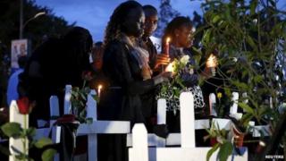 Kenyans hold candles next to wooden crosses symbolising the victims of an attack by gunmen at Garissa University College, during a memorial vigil at the Freedom Corner in Kenya's capital Nairobi o 7 April 2015