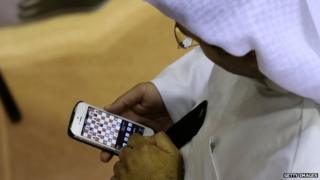 An Emirati man plays chess on his mobile phone during the FIDE World Rapid & Blitz Chess Championships 2014 at Dubai Chess and Culture Club (19 June 2014)