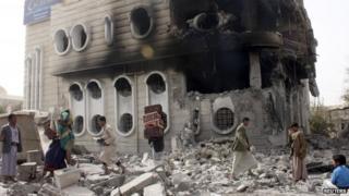 People salvage belongings from a government bank that was hit during an air strike in Yemen"s northwestern city of Saada April 16, 2015