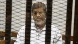 Mohammed Morsi inside a dock at a court in Cairo, Egypt (8 May 2014)