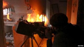 Syrian rebel fires a machine gun during clashes with government forces south of Damascus (22 April 2015)