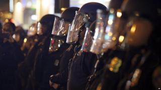 Police standing in a line with masks