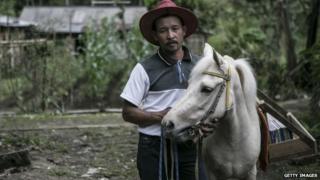 42 year old Ridwan Sururi with Luna, a horse used as mobile library on May 5, 2015 in Serang Village, Purbalingga, Central Java Indonesia.